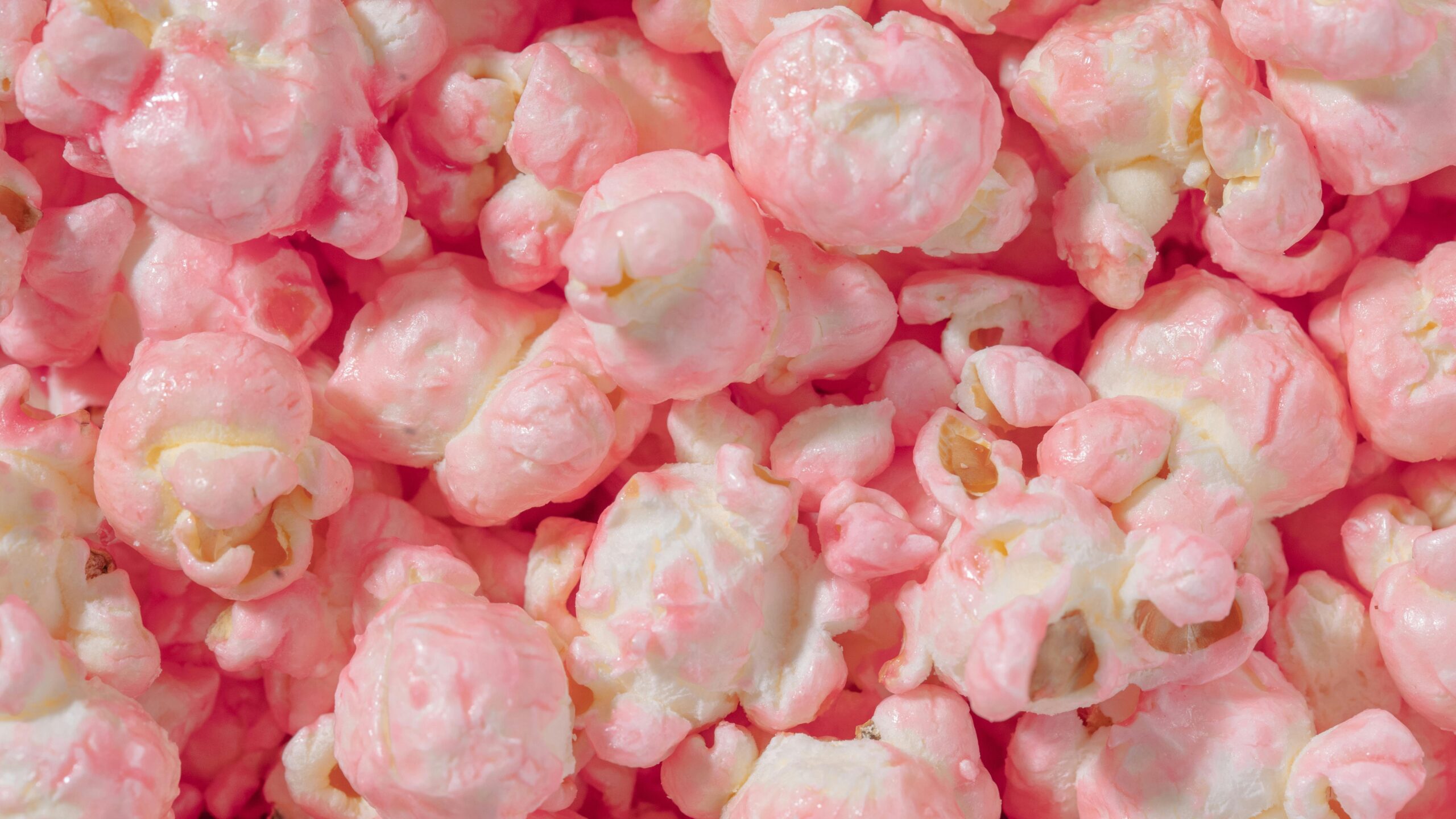 A delightful close-up of pink caramel popcorn with a soft, sugary texture.